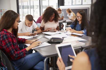 Group of students with devices in classroom setting