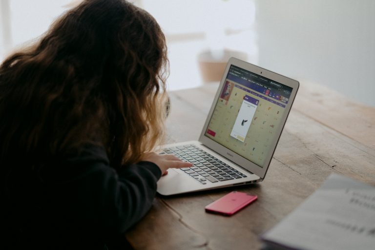 Student at home sitting in front of open laptop working.